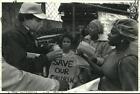 1993 Press Photo Robert Marquette scoops up glue to show protesters it is safe.