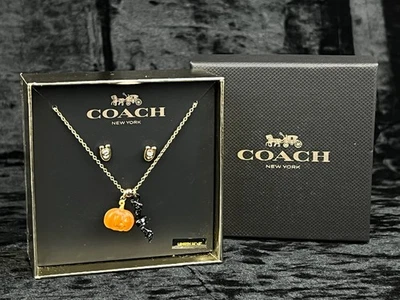 Juego de pendientes y collar de murciélago calabaza COACH tono dorado con monograma Foto 1 de 4
