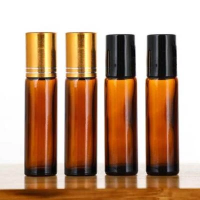 Venta al por mayor Botellas enrollables de aceite esencial de vidrio grueso color 10 ml con tapa de bola dorada Foto 1 de 4