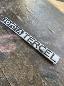 1984 Tercel Hatchback Rear Emblem ** WEAR** NEEDS NEW ADHESIVE ** - Picture 1 of 10