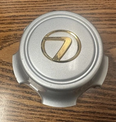 LEXUS LX470 1998-2002 OEM TAPA CENTRAL PLATA ORO LOGO 42603-60231 Foto 1 de 4