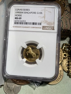 Moneda de caballo de oro Singapur SM 1990 G10S NGC MS69 (baja acuñación) 1/10 .9999  Foto 1 de 4