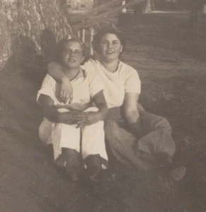 Two Women Sitting Tree Trunk Embracing Friendship Casual Scene 1940s - Picture 1 of 3