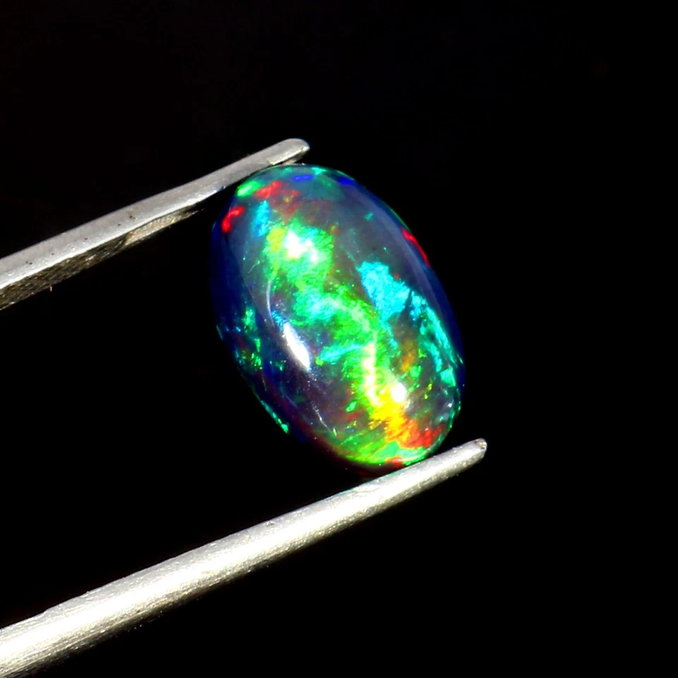 Cabujón ovalado de ópalo negro natural - 12x8x5 mm 2,50 quilates ópalo suelto de fuego verde y azul. Foto 1 de 4