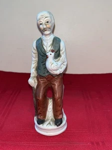 VINTAGE BISQUE PORCELAIN 6.75” OLD MAN FIGURE HOLDING ROOSTER CHICKEN HEN BIRD - Picture 1 of 8