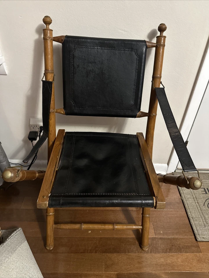 Silla de madera plegable vintage de campaña colonial de cuero negro y latón imitación bambú Foto 1 de 4