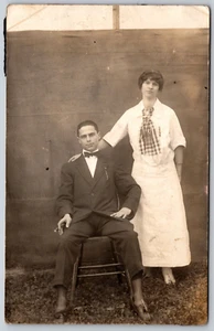 RPPC Couple Outside Man Sitting Bowtie Suit Cigar Woman Gingham Scarf 1910s - Picture 1 of 2