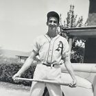 man in baseball uniform holding wooden bat vintage photograph