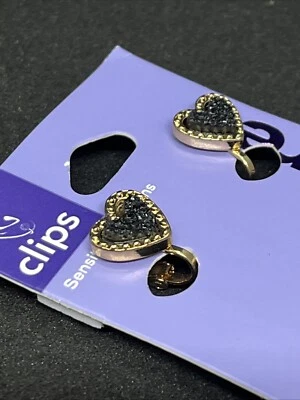 Pendientes de clip de Claire. Oro con centro corazón negro. Foto 1 de 3