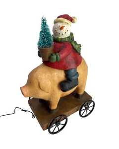 Schneemann auf einem Schwein hält einen Weihnachtsbaum auf einem Wagen mit einer Zugleine - Bild 1 von 12