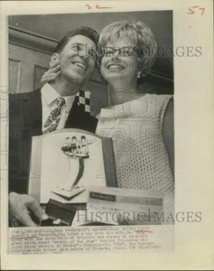 Foto de prensa 1965 Mario Andretti y su esposa Dee Ann posan con trofeos, Indianápolis - Imagen 1 de 2