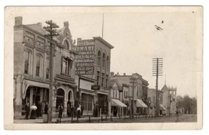 LAKE MILLS WISCONSIN STREET SCENE RPPC CARTOLINA GEO H BRUNS HARDWARE - Foto 1 di 2