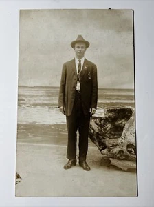 c.1920 Mann im Anzug steht unbeholfen Strand Hintergrund RPPC echtes Foto Postkarte - Bild 1 von 9