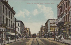 Main Street Crowd Action Fostoria IA Trolley On Tracks Signs 1910 postcard MQ4 - Picture 1 of 2