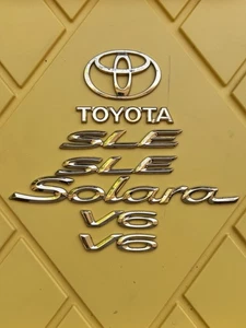 OEM FRONT AND BACK GOLD TOYOTA SOLARA SLE V6 TRUNK EMBLEM - Picture 1 of 1