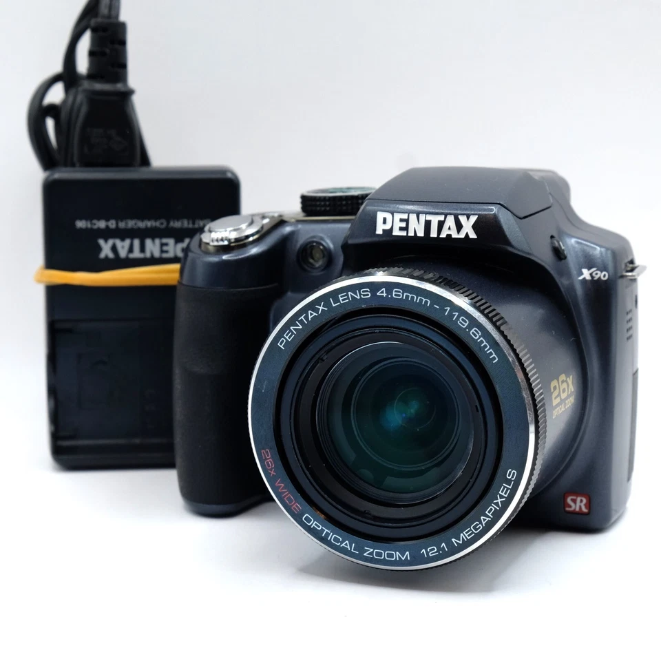 Cargador lente zoom óptico 26x cámara puente digital sensor CCD Pentax X90 12,1 MP Foto 1 de 4
