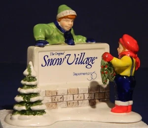 Departamento 56 Orig Snow Village: NIÑOS DECORANDO EL LETRERO DEL PUEBLO - 51349 - Imagen 1 de 7