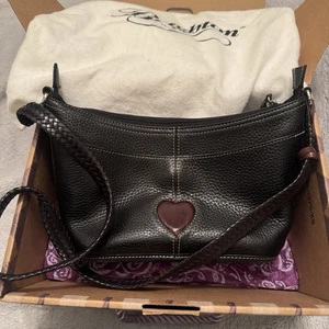 Bolso de hombro Brighton Bella de cuero negro y chocolate con dije de corazón y bolsa antipolvo - Imagen 1 de 15