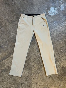 Pantalones elásticos Oakley caqui calce regular 33x32 beige rendimiento nailon golf informales - Imagen 1 de 9