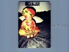 FOUND COLOR PHOTO L_3889 LITTLE GIRL IN HAT SITTING ON BED SMILING