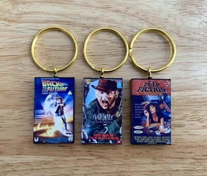 Llavero de película VHS en miniatura CUALQUIER PELÍCULA QUE DESEES Novedad llavero película - Imagen 1 de 22