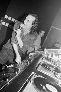 American DJ Mark Kamins with a microphone behind the turntables in - Old Photo - Picture 1 of 1