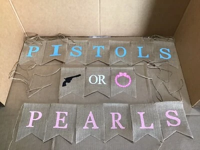 Pistolas o perlas usadas arpillera colgante revelación de género pancarta con collares Foto 1 de 4