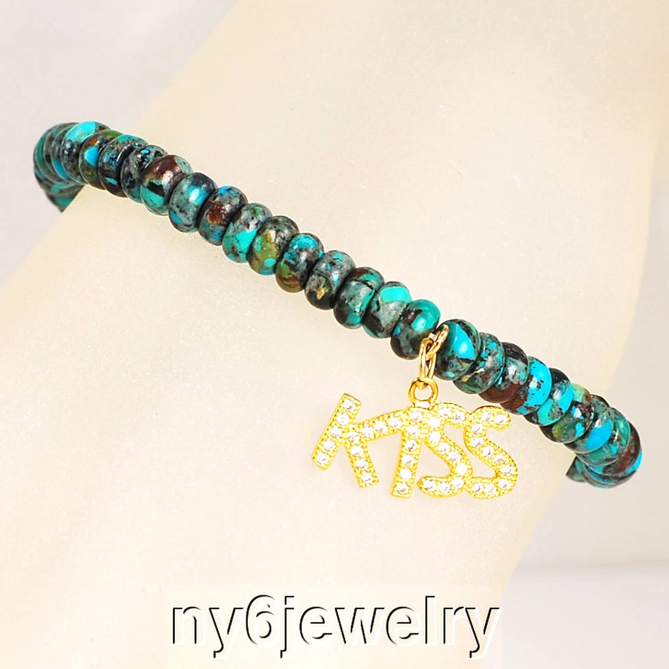 Pulsera elástica Rondelle turquesa natural con tono dorado y dije "beso" circonita cúbica 7" Foto 1 de 1