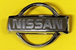 Adorno emblema capó camioneta Nissan D21, 1995-1997 OEM ¡NUEVO! - Imagen 1 de 3