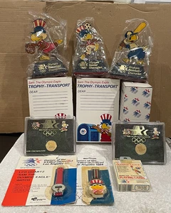 1984 OLYMPIC GAMES MEMOROBILIA TROPHY TRANSPORT, PIN SETS, PLAYING CARDS,WATCHES - Picture 1 of 9