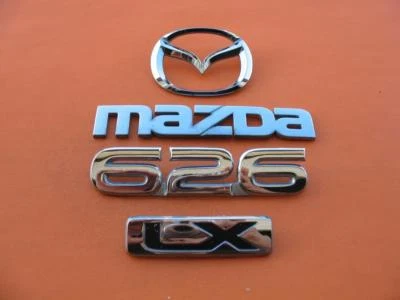 98 99 00 01 02 MAZDA 626 LX TAMPA TRASEIRA DO PORTA-MALAS EMBLEMA LOGOTIPO EMBLEMA SÍMBOLO CONJUNTO FABRICANTE DE EQUIPAMENTO ORIGINAL - Imagem 1 de 4