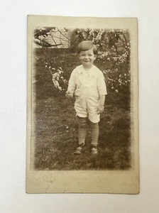 Early 1900s RPPC Young Boy Child Long Socks Cute Smile Outside Flowers Unposted - Picture 1 of 7