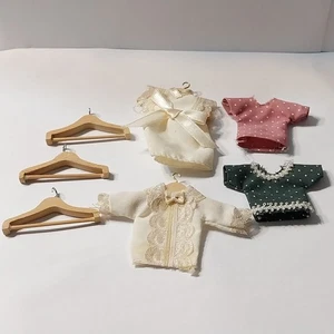 Konvolut 7 Teile Puppenhaus Miniatur Holz Kleiderbügel & Babykleidung - Bild 1 von 13