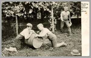 Tarjeta postal chupando sidra a través de una pajita RPPC niños granjero de barril UDB 1900-1905 - Imagen 1 de 2