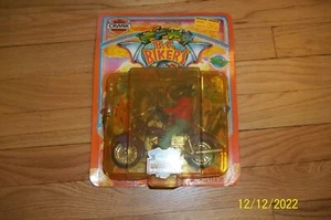 B.C. Bikers motorisierter Dinosaurier (1993) CRANK THE MANIAC MECHANIKER lila Fahrrad neu in Verpackung - Bild 1 von 4