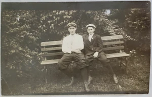 Postal de dos hombres jóvenes en banco RPPC sin publicar - Imagen 1 de 2