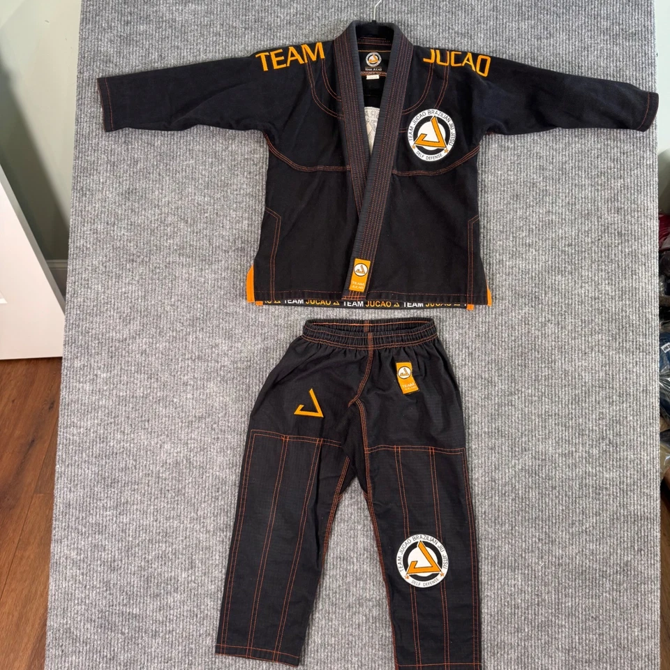 Team Jucao BJJ Gi Youth C-1 Preto Laranja Brazilian Jiu Jitsu Uniforme Arte Marcial - Imagem 1 de 4