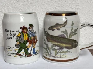 2 Bierkrüge 0,5l Porzellan weiß mit Anglermotiv (Fische) und Wandermotiv - Bild 1 von 6