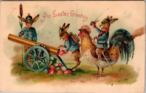 SALUTO PASQUA - CONIGLI VESTITI SPARANO UOVA CANONE - CARTOLINA D'EPOCA IN RILIEVO - Foto 1 di 2