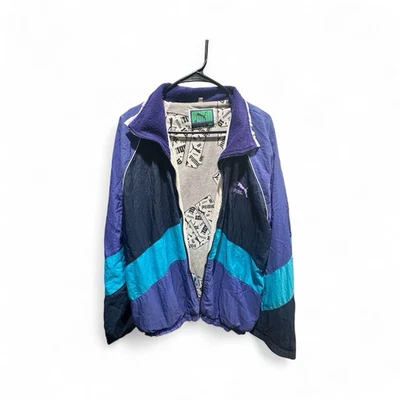 Chaqueta cortavientos vintage PUMA unisex negra/púrpura/azul talla XL 90s Foto 1 de 2