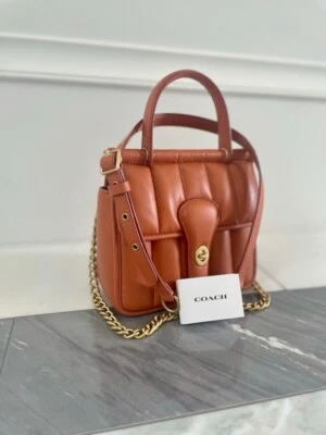 This NWT, never-used Coach top handle bag is in the iconic "Coach Brown" shade.  - Image 1 of 4