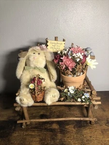 Easter bunny stuffy sitting on a wooden bench with flower - Picture 1 of 11