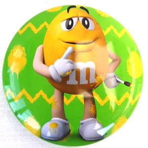 M&M'S BOITE METAL VIDE CACAHOUETTE JAUNE FOND VERT 19 cm de diametre 2019 - Imagen 1 de 3