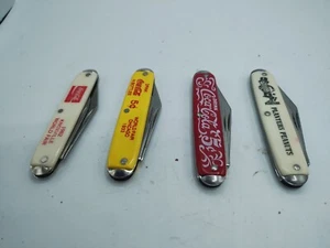 Lotto di 4 Coltelli Jack Coco Cola Fioriere Arachidi Vintage Inc 2 Fiera Mondiale... - Foto 1 di 12