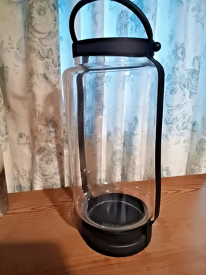 Cylindrical glass  candle/hurricane lamp in black metal frame with handle. - Image 1 of 3