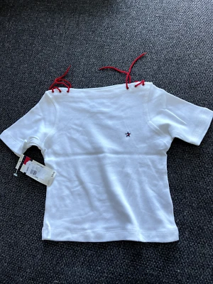 NUEVO CON ETIQUETAS Tommy Hilfiger Camisa Niña Blanca con Cuerdas Rojas Talla 4 Precio de venta sugerido por el fabricante $30 Foto 1 de 3