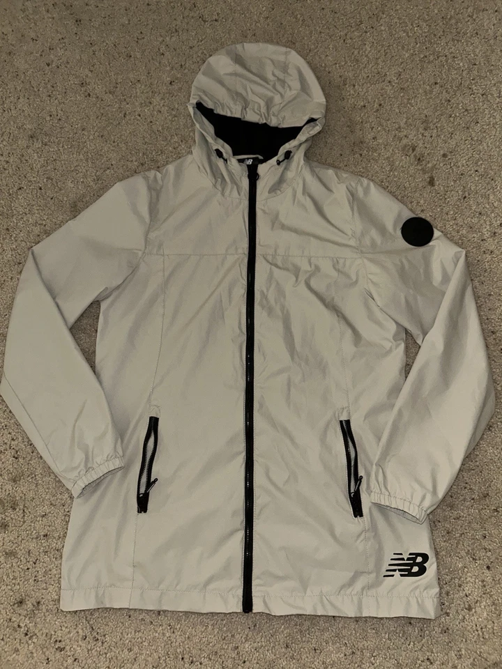 Chaqueta cortavientos New Balance para mujer con capucha beige negra talla mediana Foto 1 de 4
