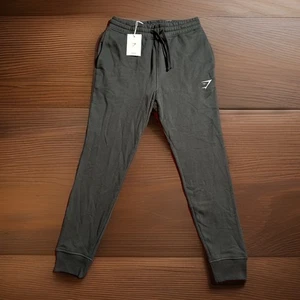 Gymshark Pantaloni da Allenamento Uomo Nero Crest Joggers Coulisse XS NUOVI CON ETICHETTE - Foto 1 di 7