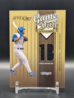 Camiseta Carlos Delgado Reliquia/300 2004 Donruss Studio Día del Juego Souvenirs #GD-89 Foto 1 de 3