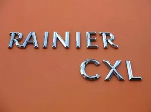 04 05 06 07 BUICK RAINIER CLX TAPA PUERTA TRASERA EMBLEMA CROMO LOGOTIPO INSIGNIA SIGNO FABRICANTE DE EQUIPOS ORIGINALES #2 - Imagen 1 de 5